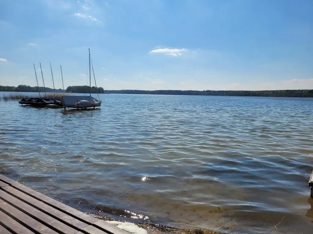 Abgedecktes Segelboot auf dem Useriner See, blauer Himmel und Sonnenschein. 